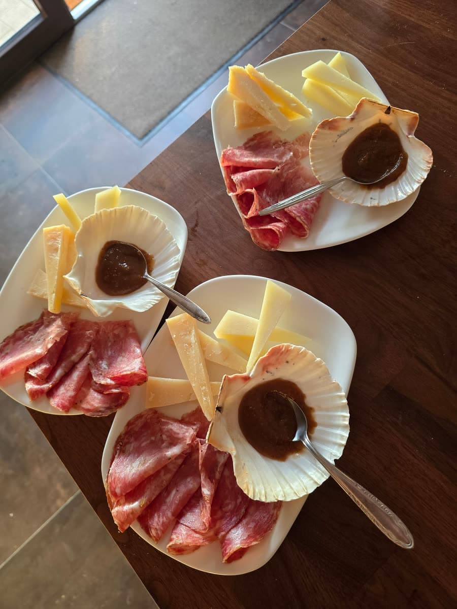 Vorspeisenteller mit Schinken, Käse und einem Schälchen Honig