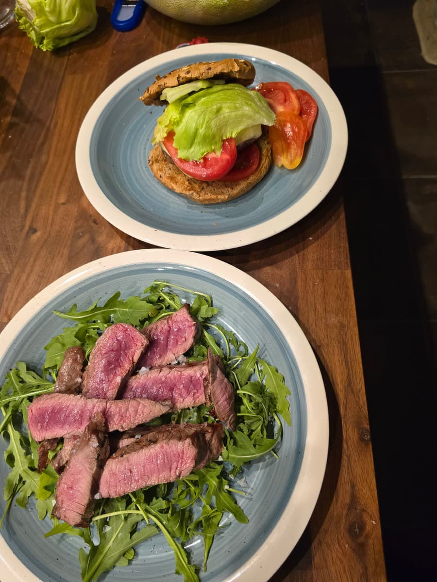 Ein Burger und eine Tagliata vom Rind auf Rucola