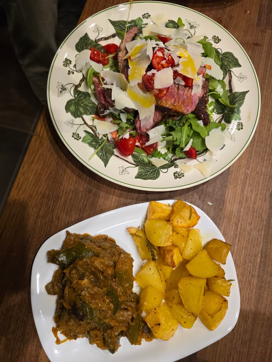 Ein bunter Salat und ein Schmorgericht mit gebratenen Kartoffeln